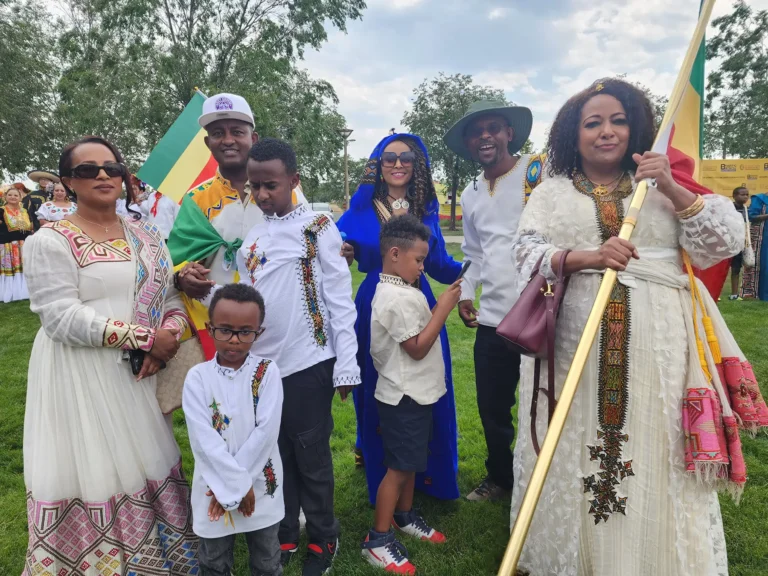 A family wearing traditional African attire and carrying flags