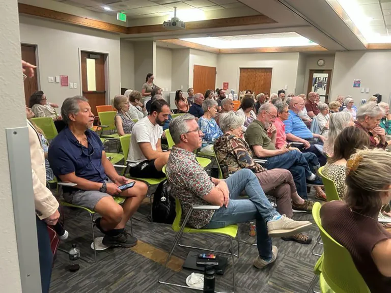 A group of people sitting in chairs gathered in a large community space