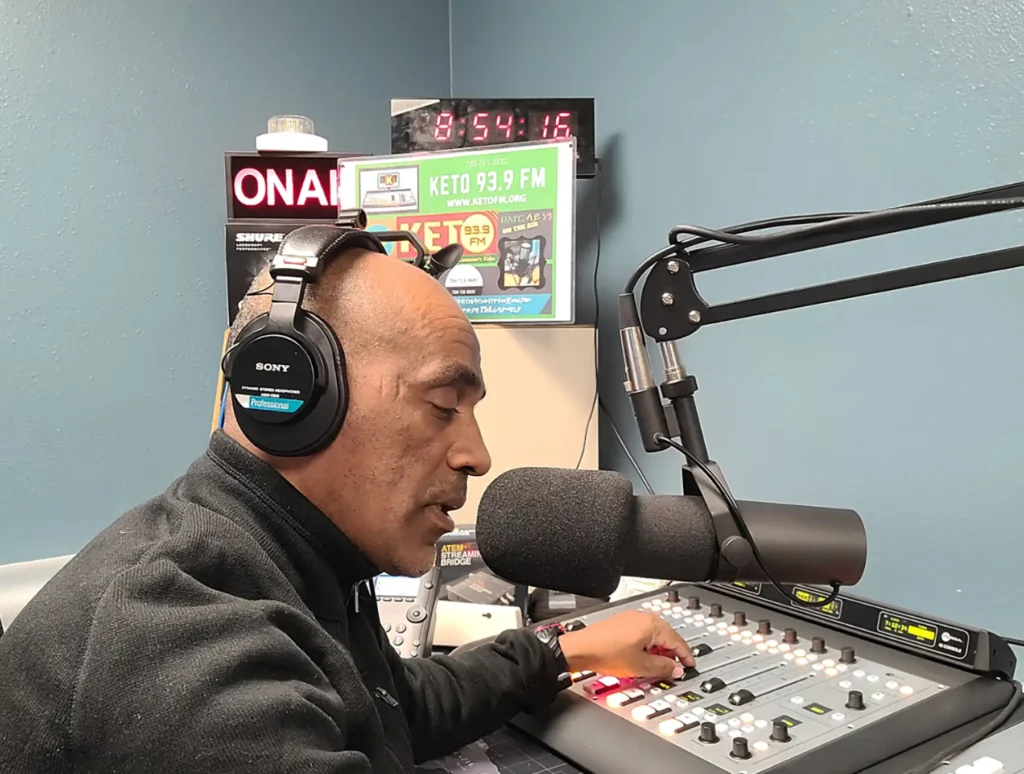 A radio host speaks into a microphone