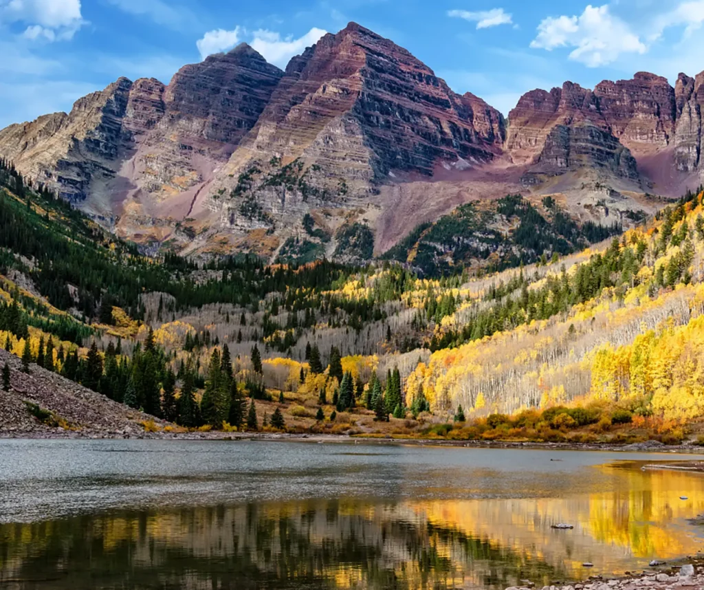 A wide shot of a mountain range with a lake at the base